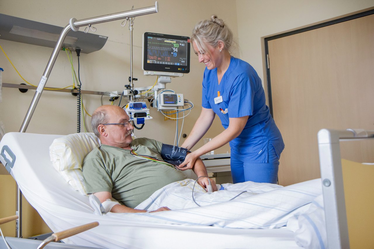 Schwester beim Blutdruck messen auf der Stroke Unit