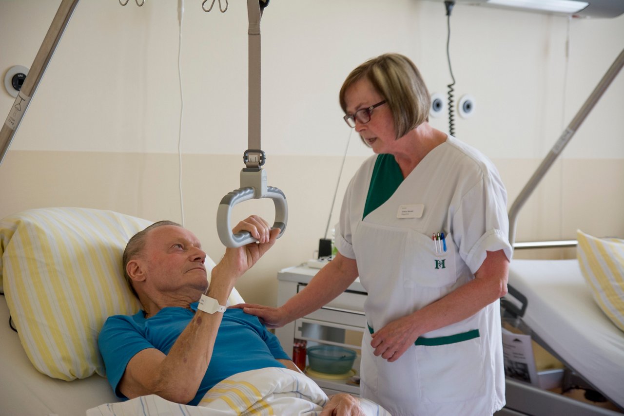 Schwester steht am Patientenbett