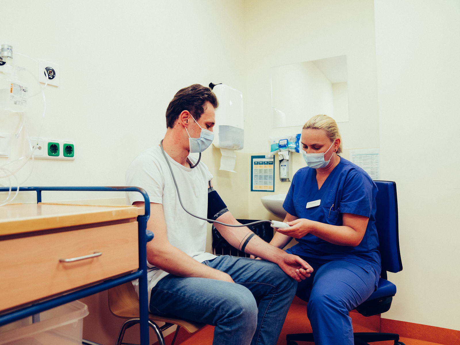 Krankenschwester liest das Ergebnis von der Blutdruckmessung ab