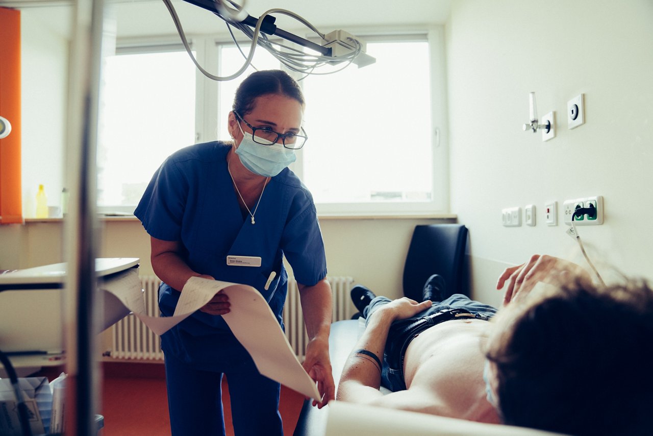 Auswertung des EKGs Patient liegt auf Behandlungsliege