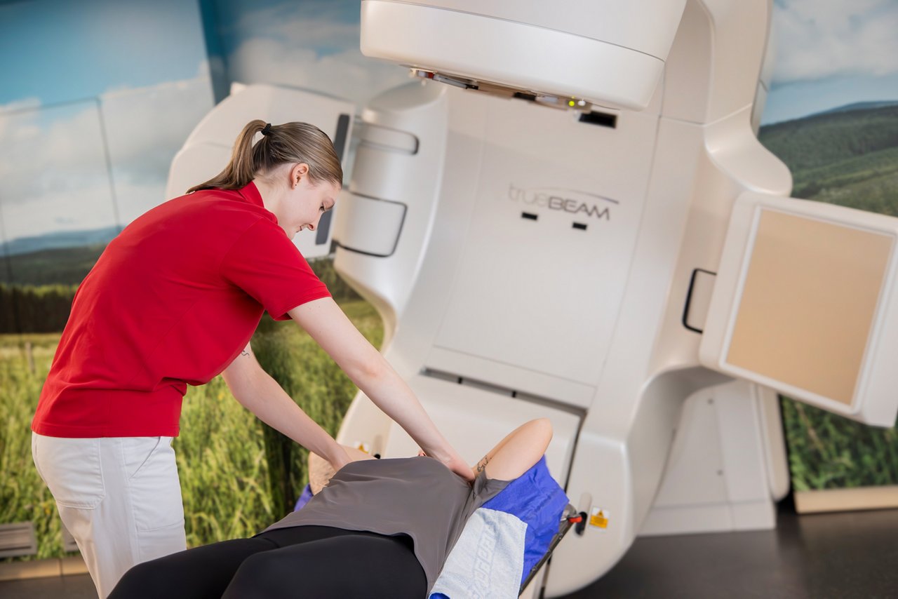Patientin wird von einer Frau auf dem Linearbeschleuniger positioniert und vorbereitet für eine Bestrahlung der Lunge