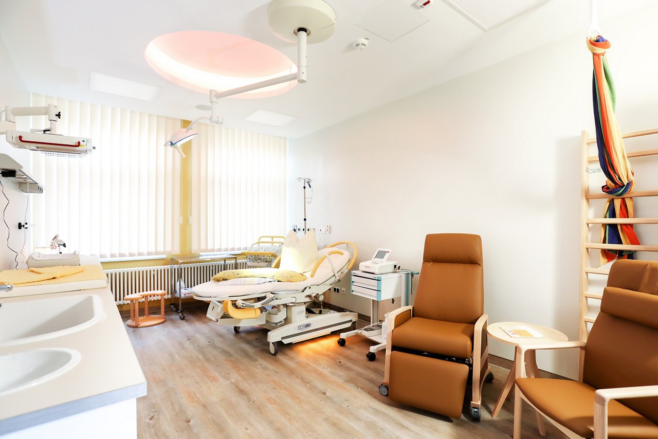 Kreißsaal mit Entbindungsbett und Gebärhocker