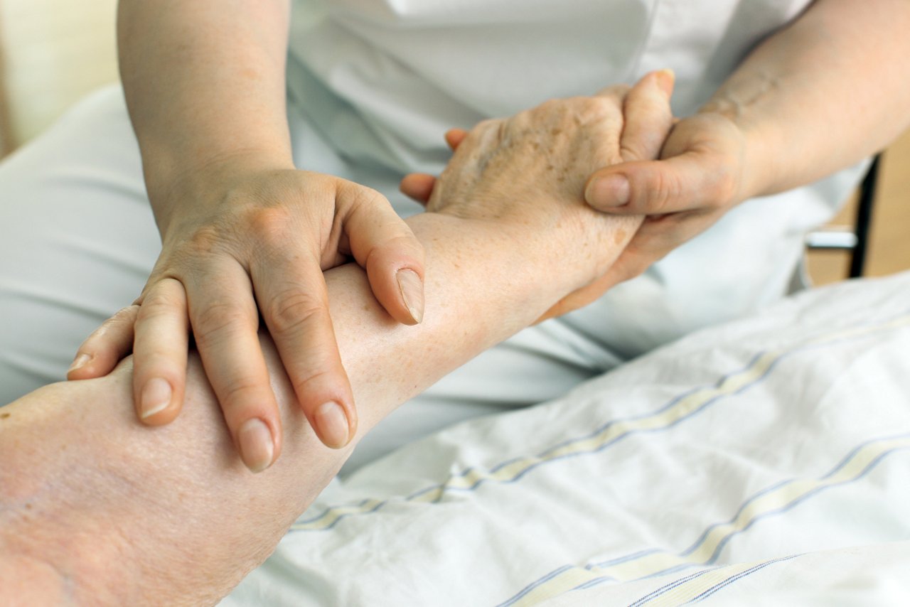 Schwester hält Hand von Patient