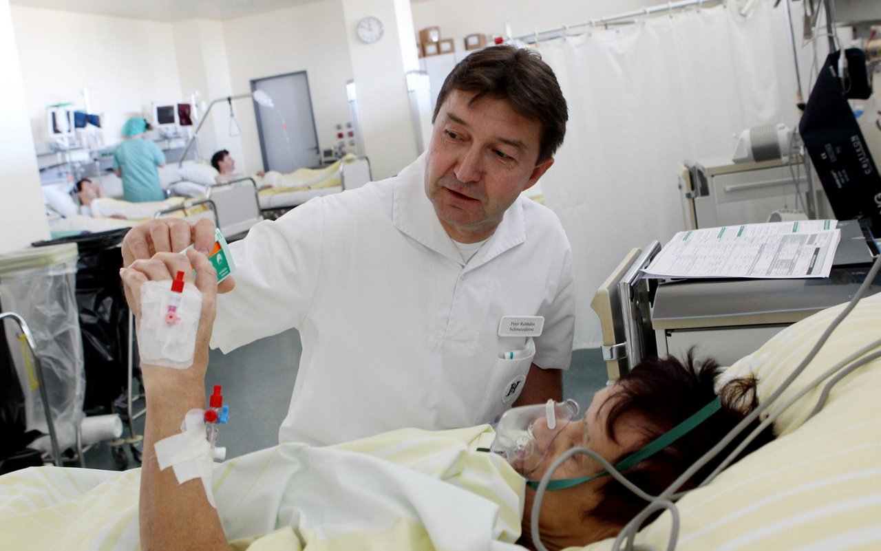 Anästhesiepflege erklärt Patientin mit Atemmaske die Medikation