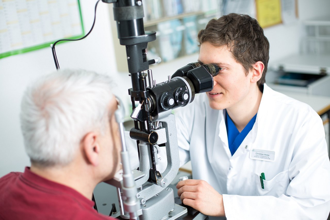Ein Augenarzt untersucht den Patienten mit einem modernen Diagnostikgerät