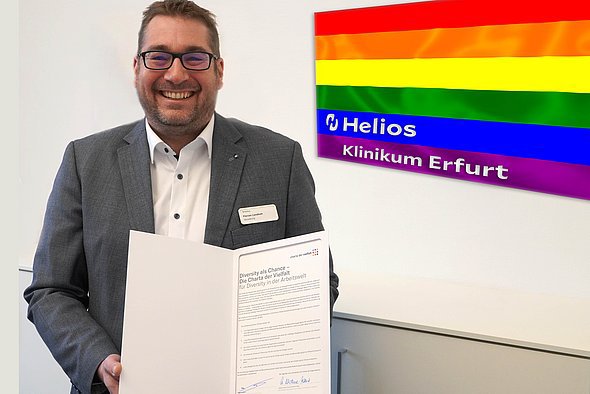 Klinikgeschäftsführer Florian Lendholt präsentiert stolz die unterschriebene "Charta der Vielfalt". 