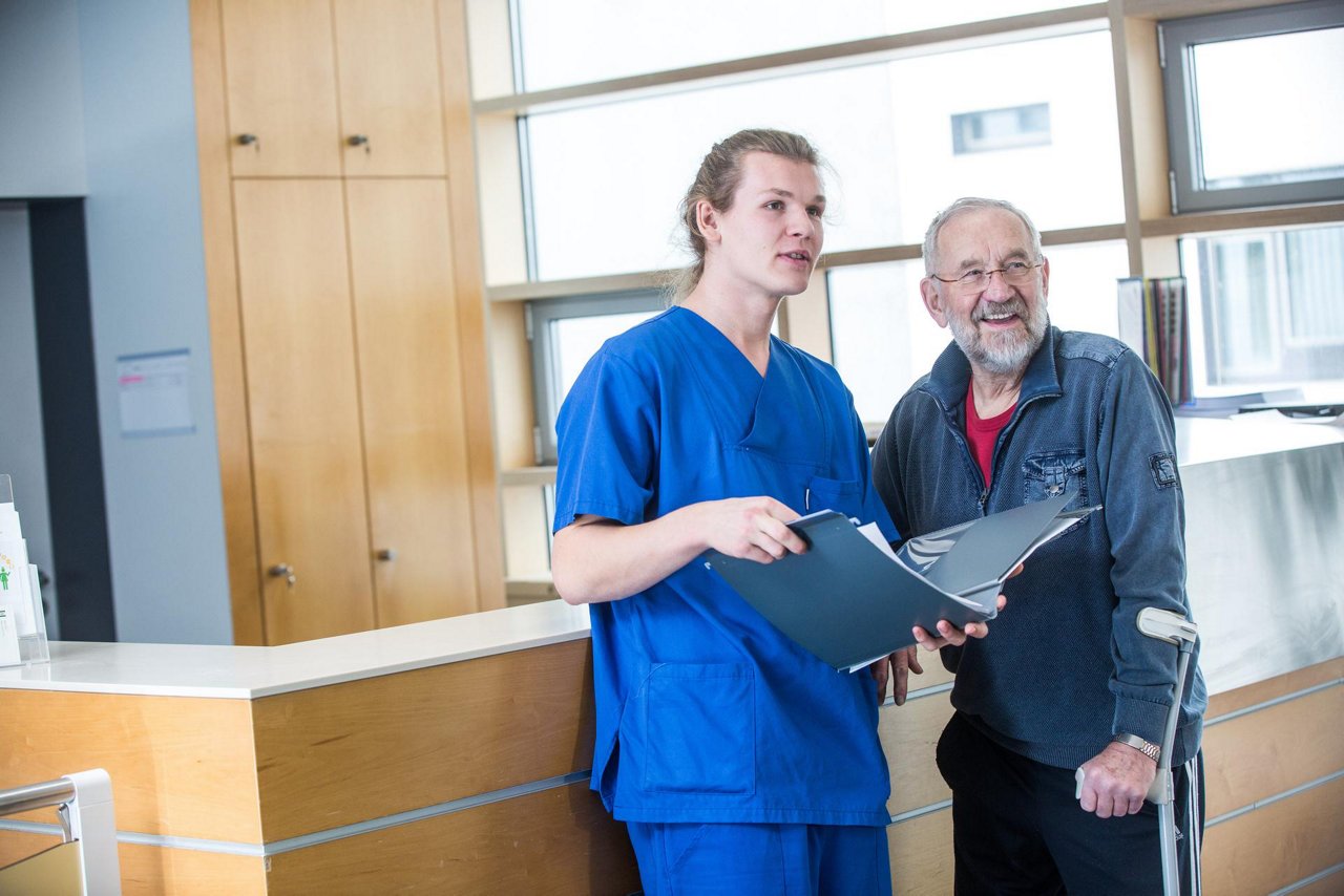 Pflegekraft erklärt Patienten etwas 