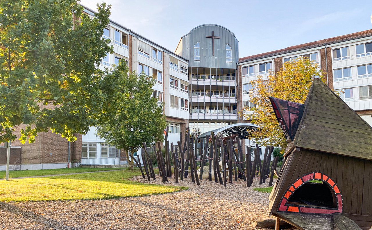 Blick von außen auf das Gebäude der Helios Sankt Elisabeth Klinik Hünfeld mit Spielplatz im Vordergrund
