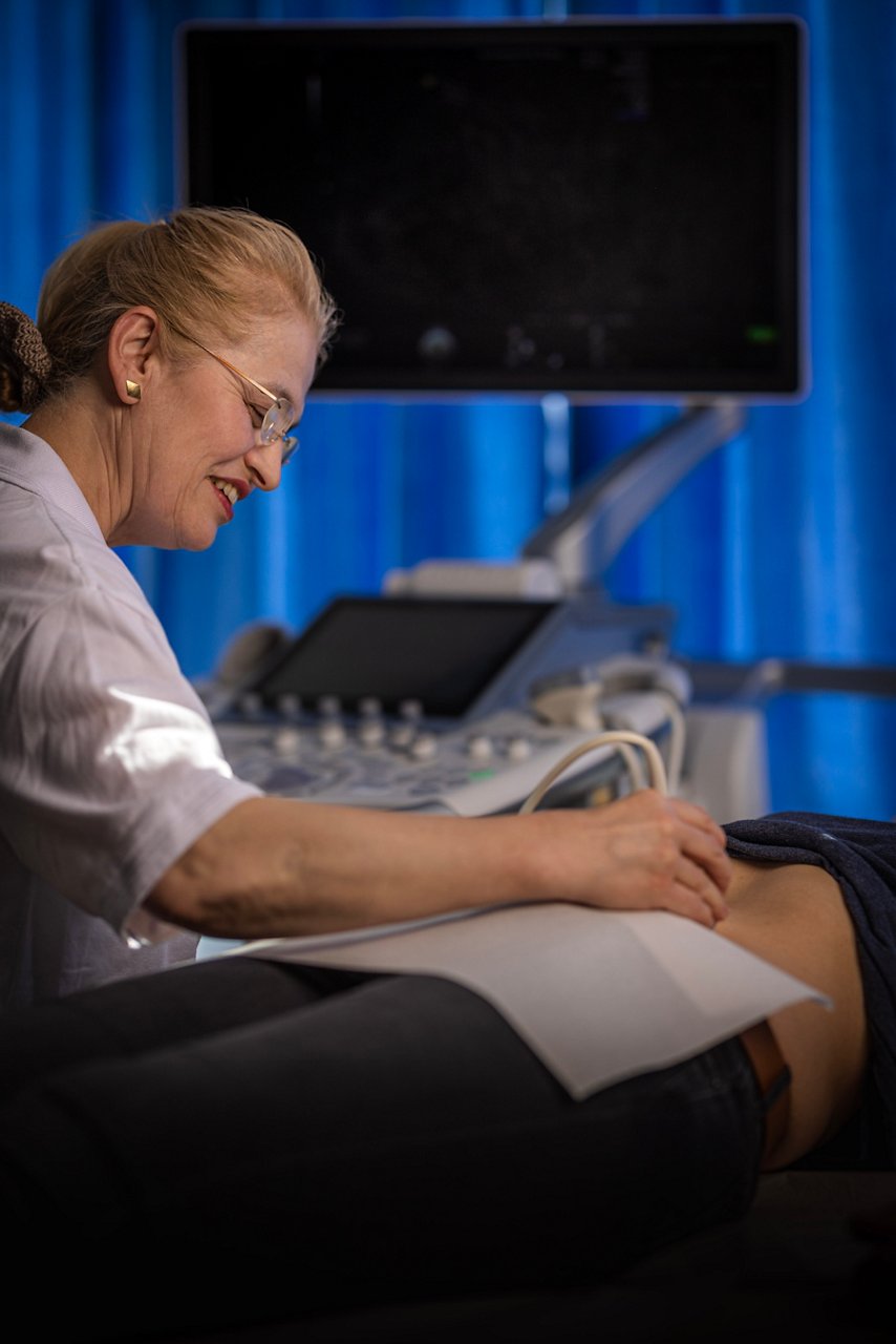 Chefärztin führt Ultraschalluntersuchung am Bauch durch