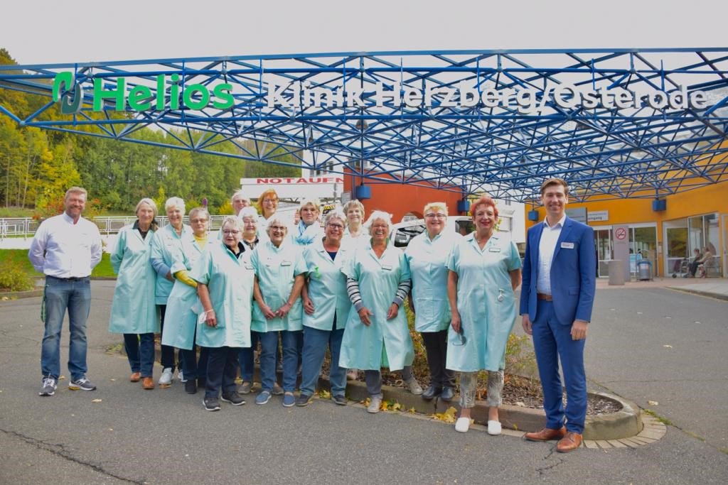 Gruppenfoto Grüne Damen mit Klinikleitung vor Klinikeingang