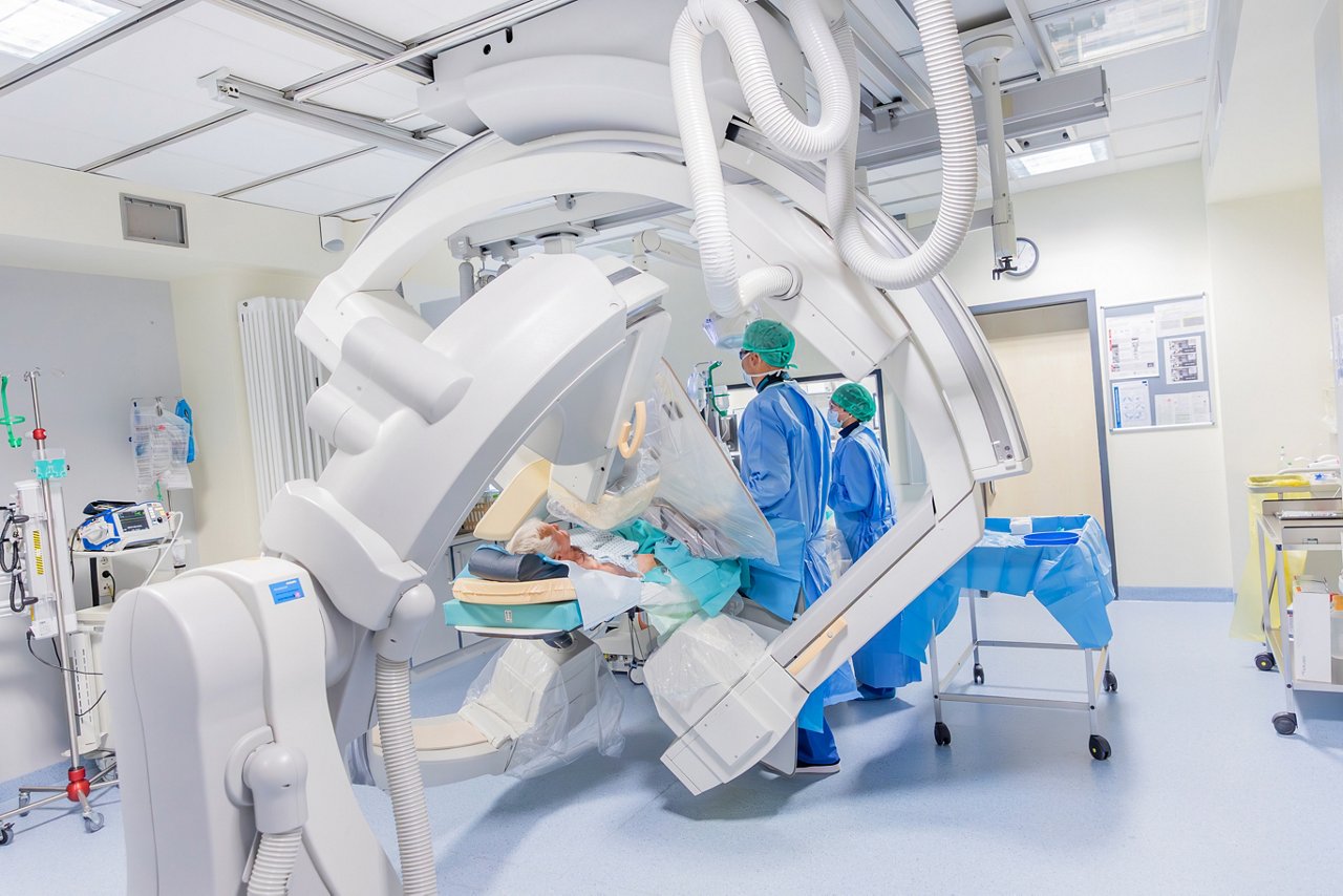 Moderne medizinische Bildgebung in einem Operationssaal. Ärzte in Schutzkleidung nutzen hochentwickelte Technologie zur Diagnose und Behandlung von Patienten.