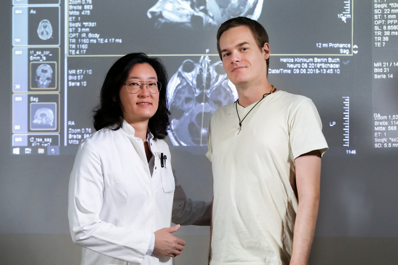 Dr. Ryang und Patient Christian Optiz blicken beide in die Kamera.  