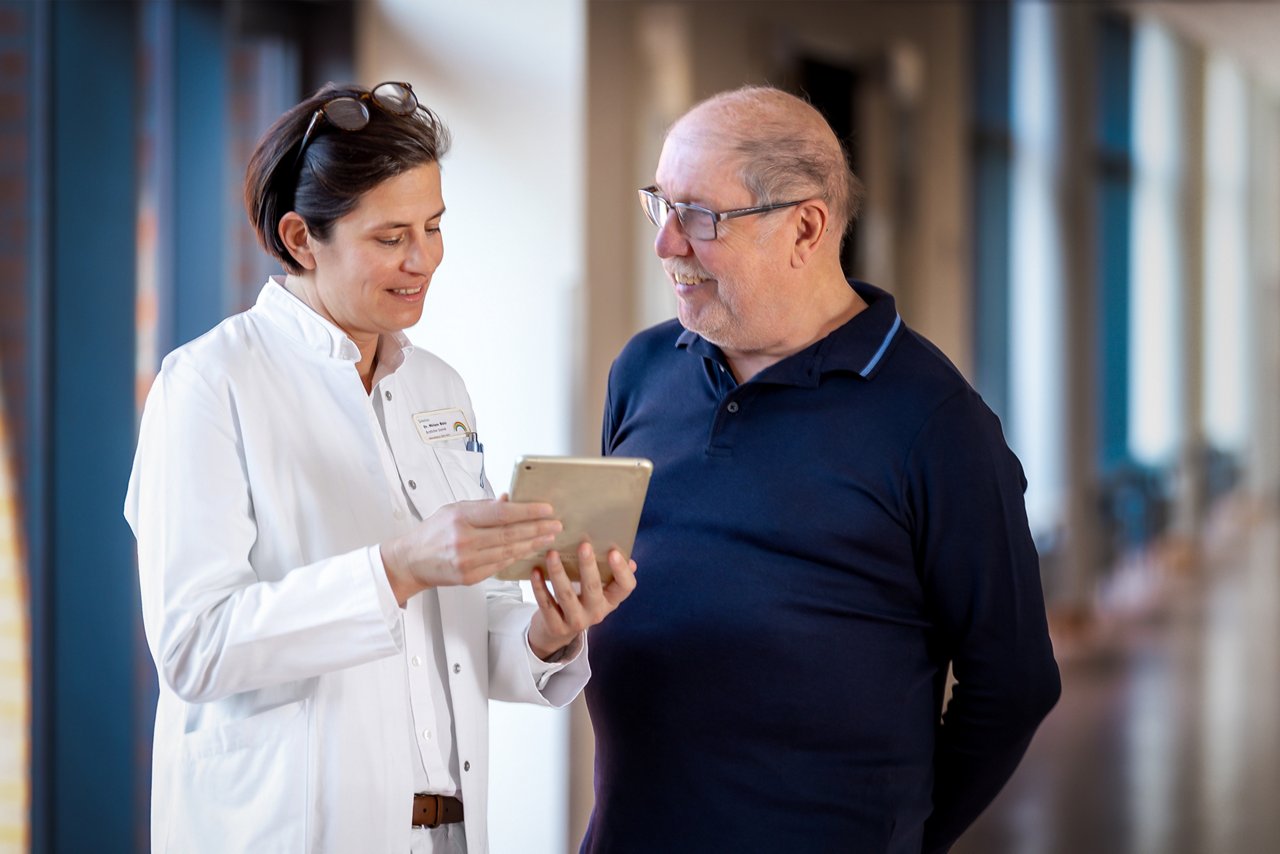Gesprächssituation zwischen Patient und Ärztin auf dem Flur