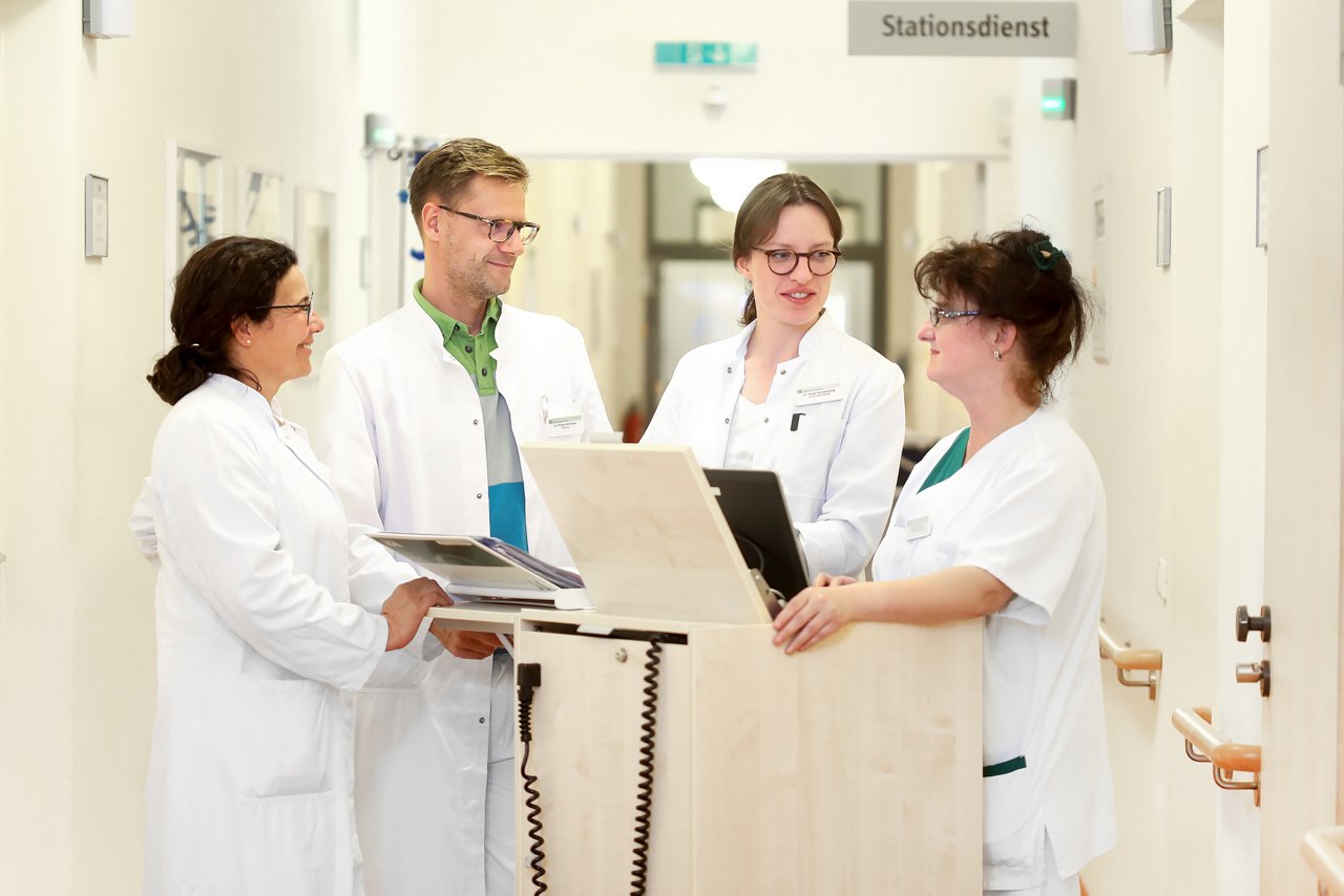 Ärzteteam der Dermatologie im Helios Klinikum Berlin-Buch stehen auf dem Stationsflur und bereiten sich auf die Visite vor
