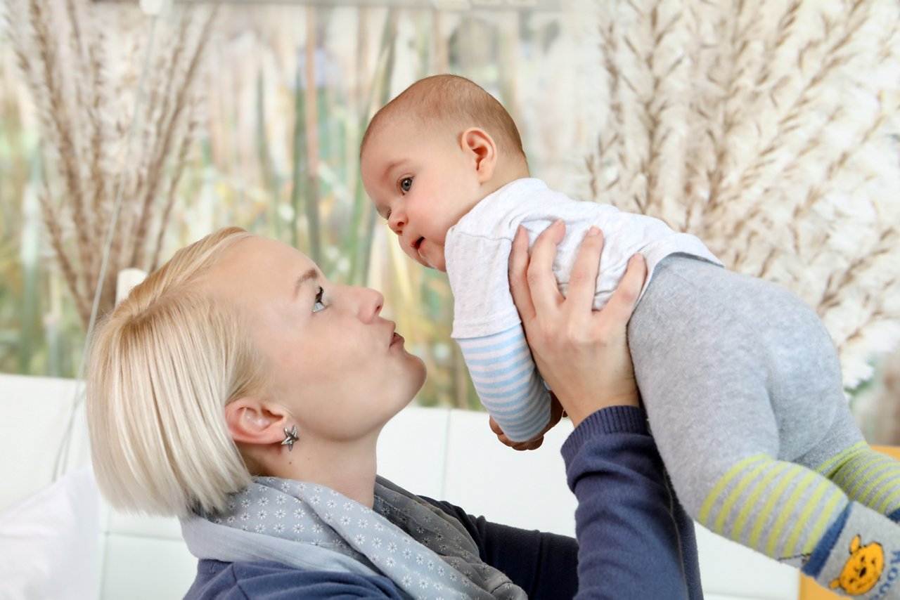 Mutter hält ihr Baby hoch 