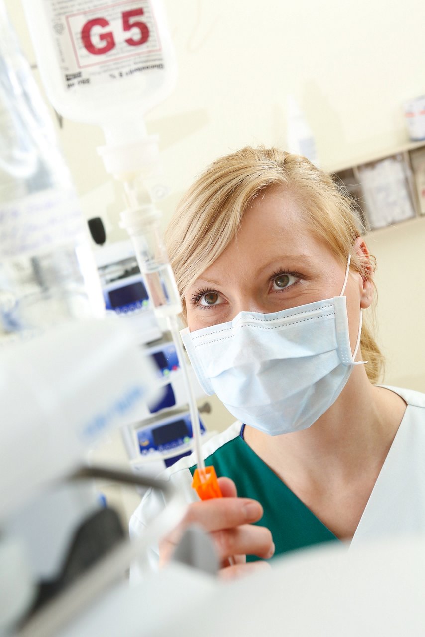 Pflegekraft stellt Infusionsgeschwindigkeit ein