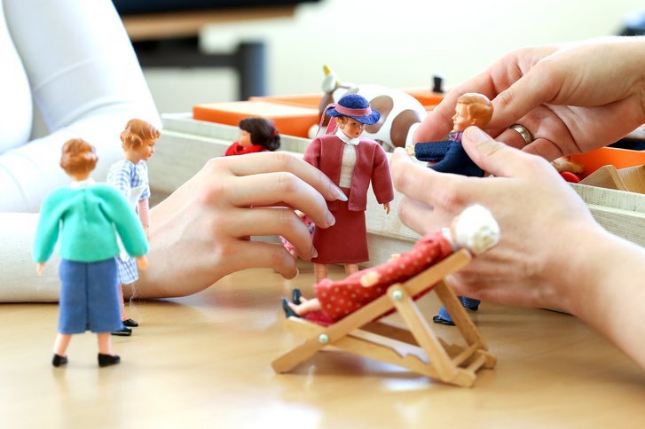 Jugendliche spielt gemeinsam mit Therapeutin mit Puppen