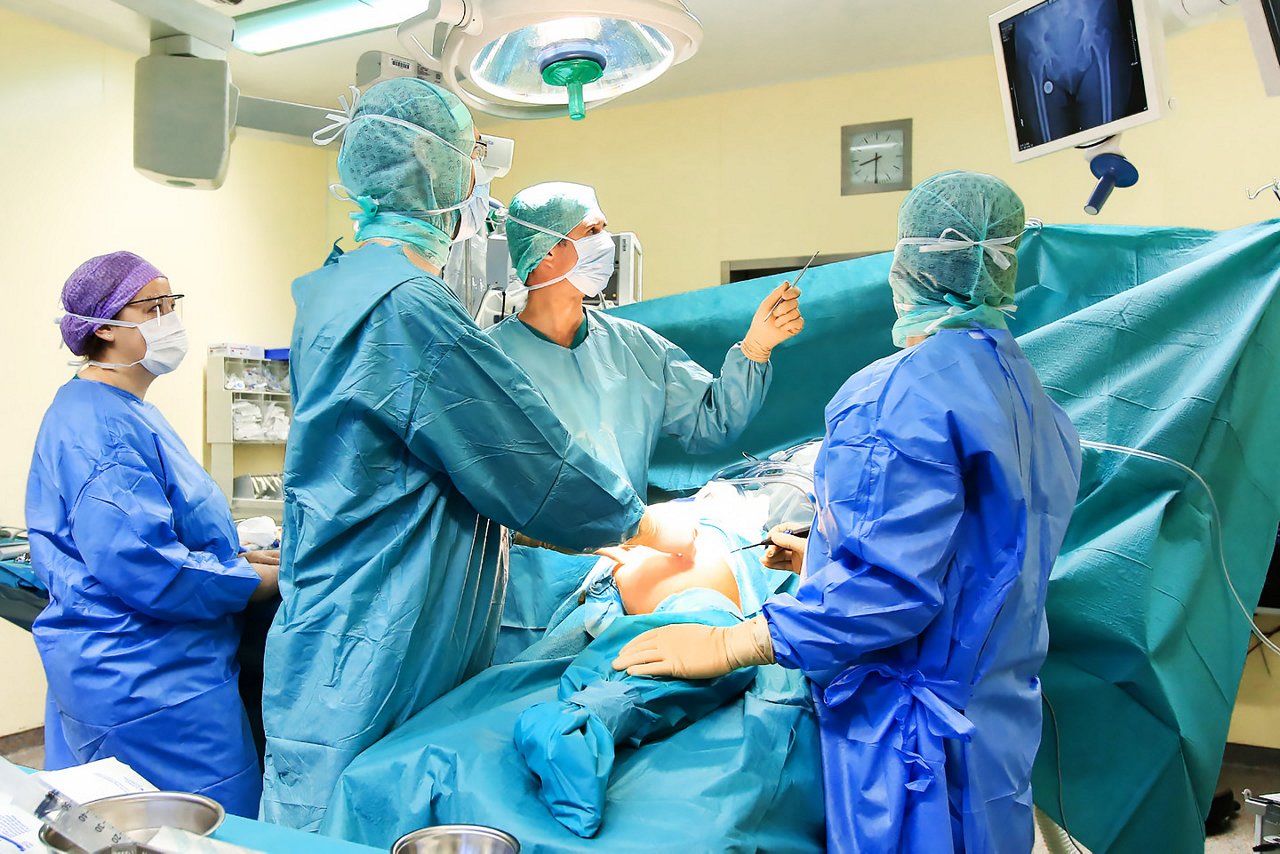 Aufklärungsgespräch zwischen Patientin und Chefarzt der Orthopädie mithilfe eines Hüftprothesenmodells