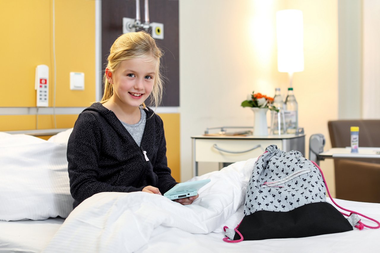 Kind sitzt im Bett der Wahlleistungsstation im Helios Klinikum Berlin-Buch