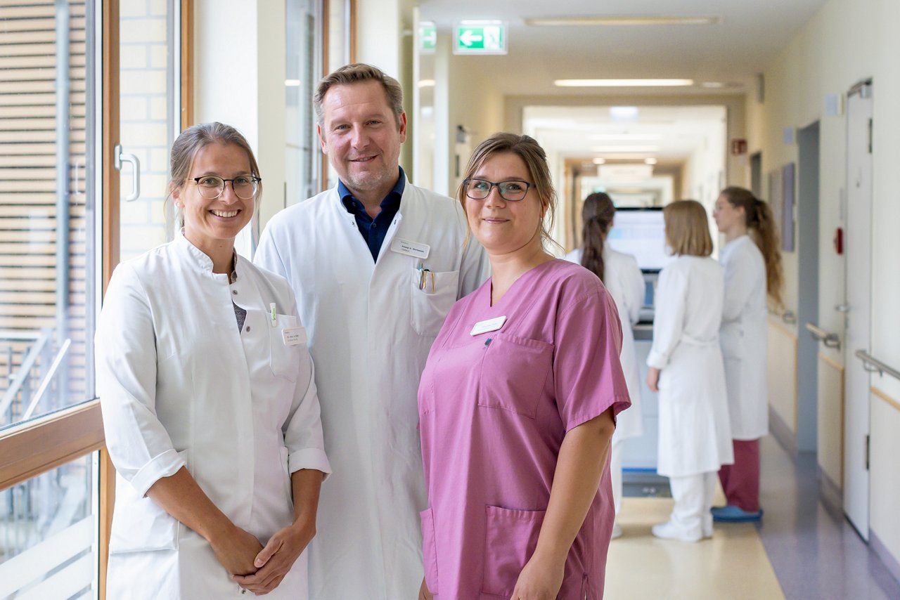 Foto von Chefarzt Dr.mef. Morawski zusammen mit Fachärztin Faßl und Stationsleitung Schwester Schumacher auf dem Stationsflur der Frauenheilkunde