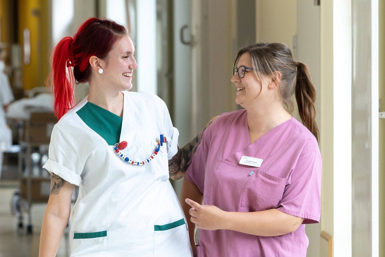 Zwei Gesundheits- und Krankenpflegerinnen der Frauenheilkunde im Gespräch auf dem Stationsflur