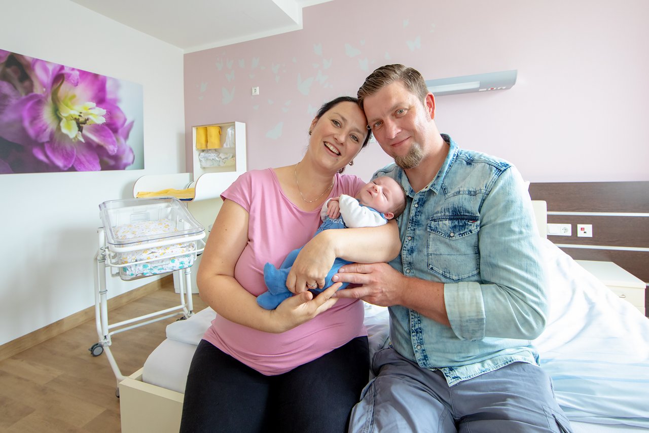 Glückliche Familie nach der Entbindung im Familienzimmer auf der Wöchnerinnen-Station im Helios Klinikum Bad Saarow