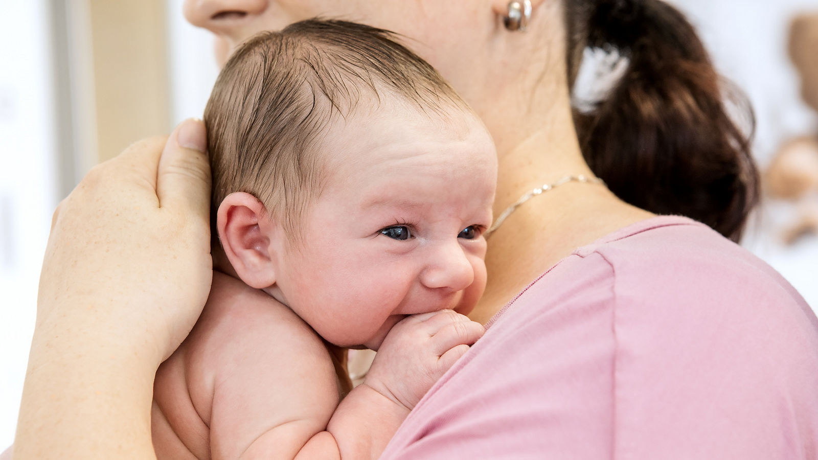 Neugeborenes im Arm der Mutter