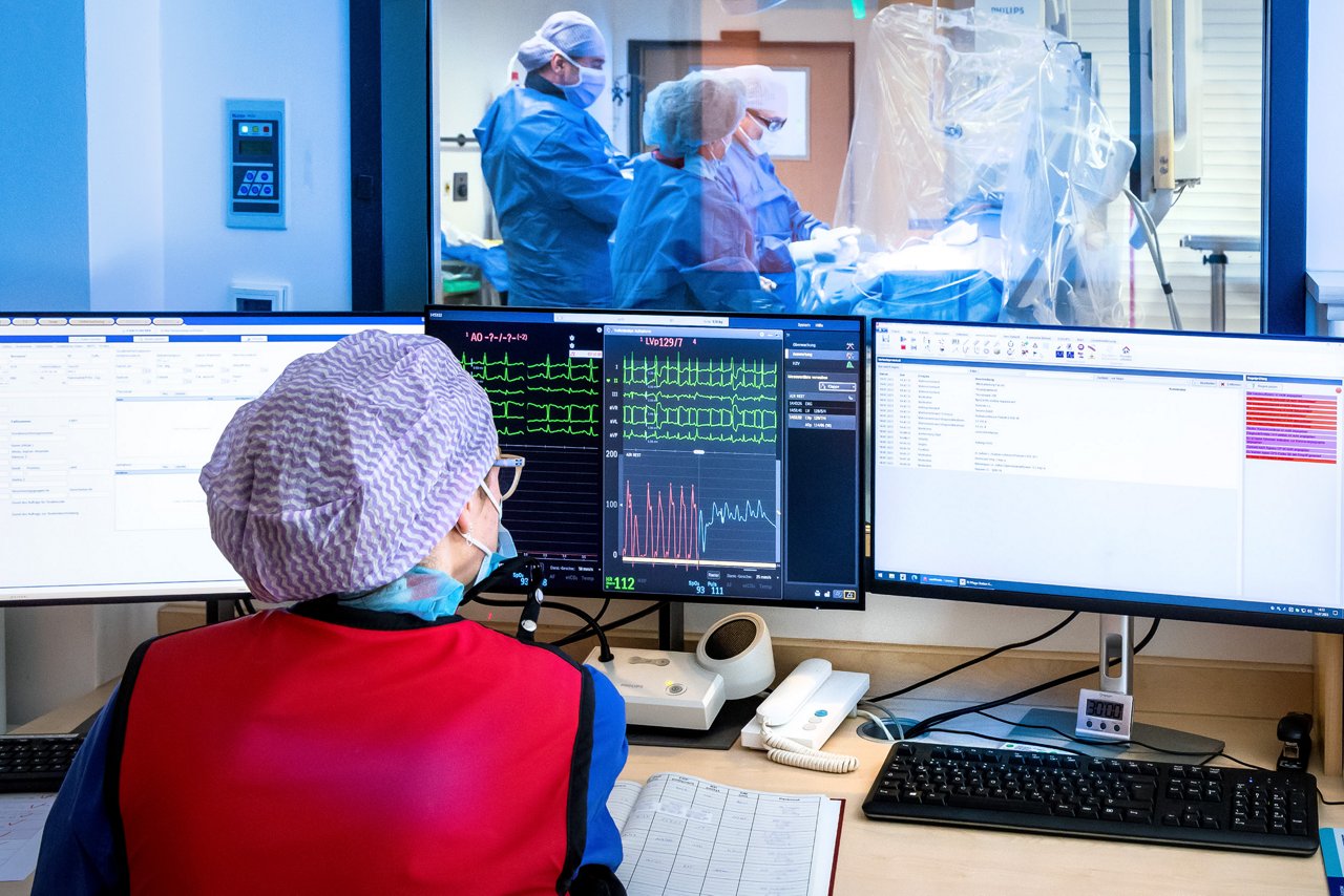 Mitarbeiterin Herzkatheterlabor am Überwachungsmonitor vor dem OP,, Helios Klinikum Bad Saarow