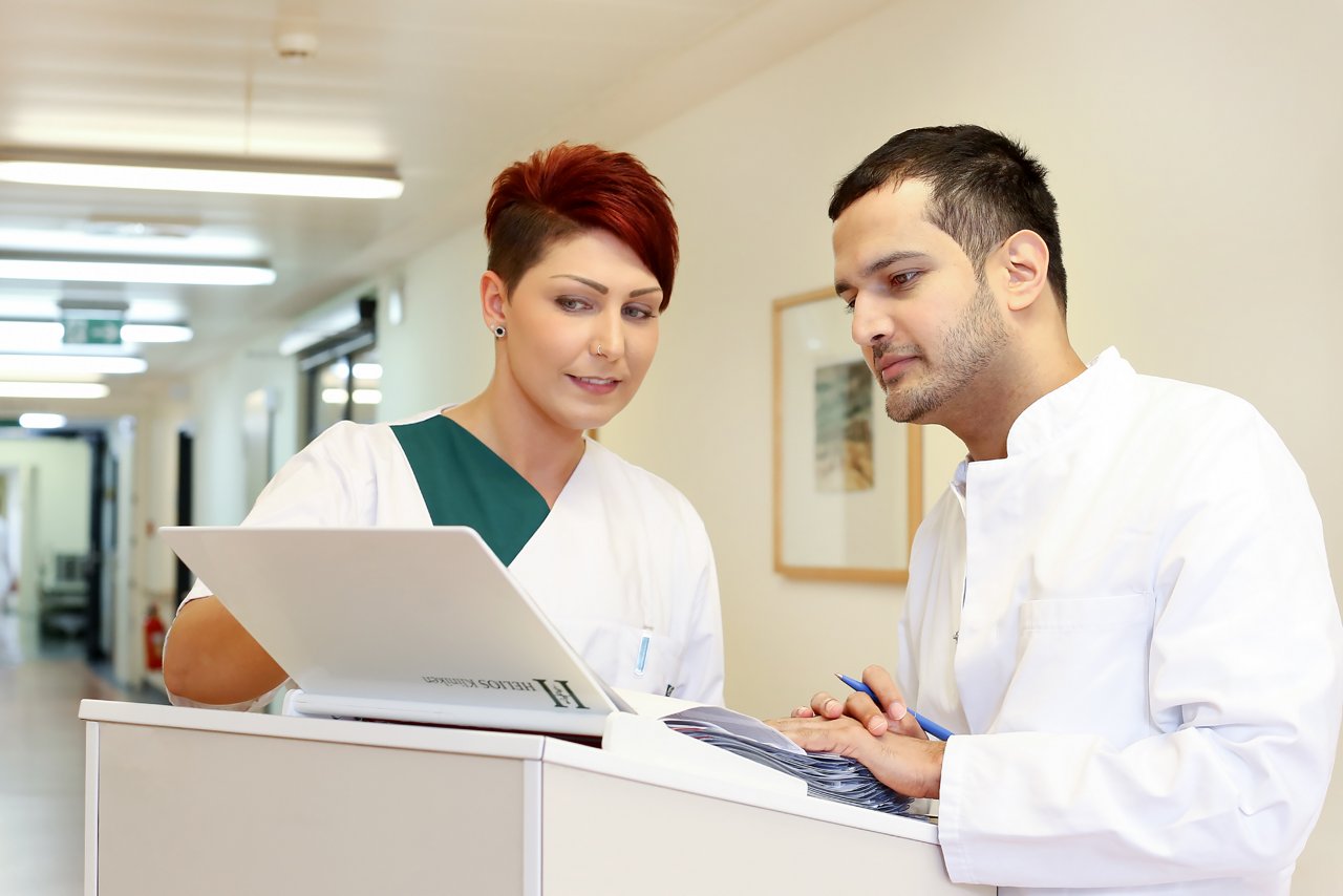 Facharzt und Stationsleitung im Austausch bei der Visite