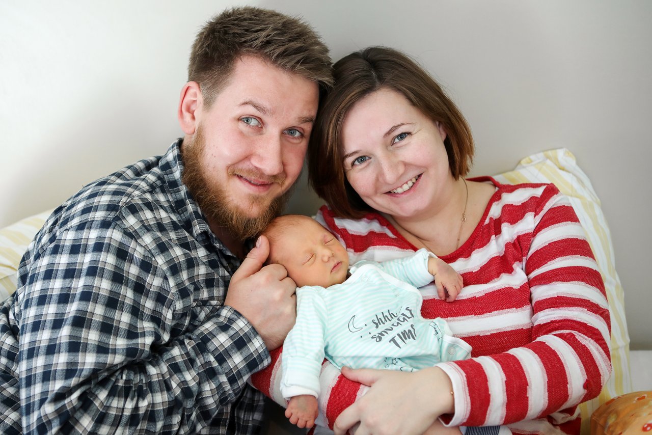 Familienfoto mit ihrem Neugeborenem  im Arm