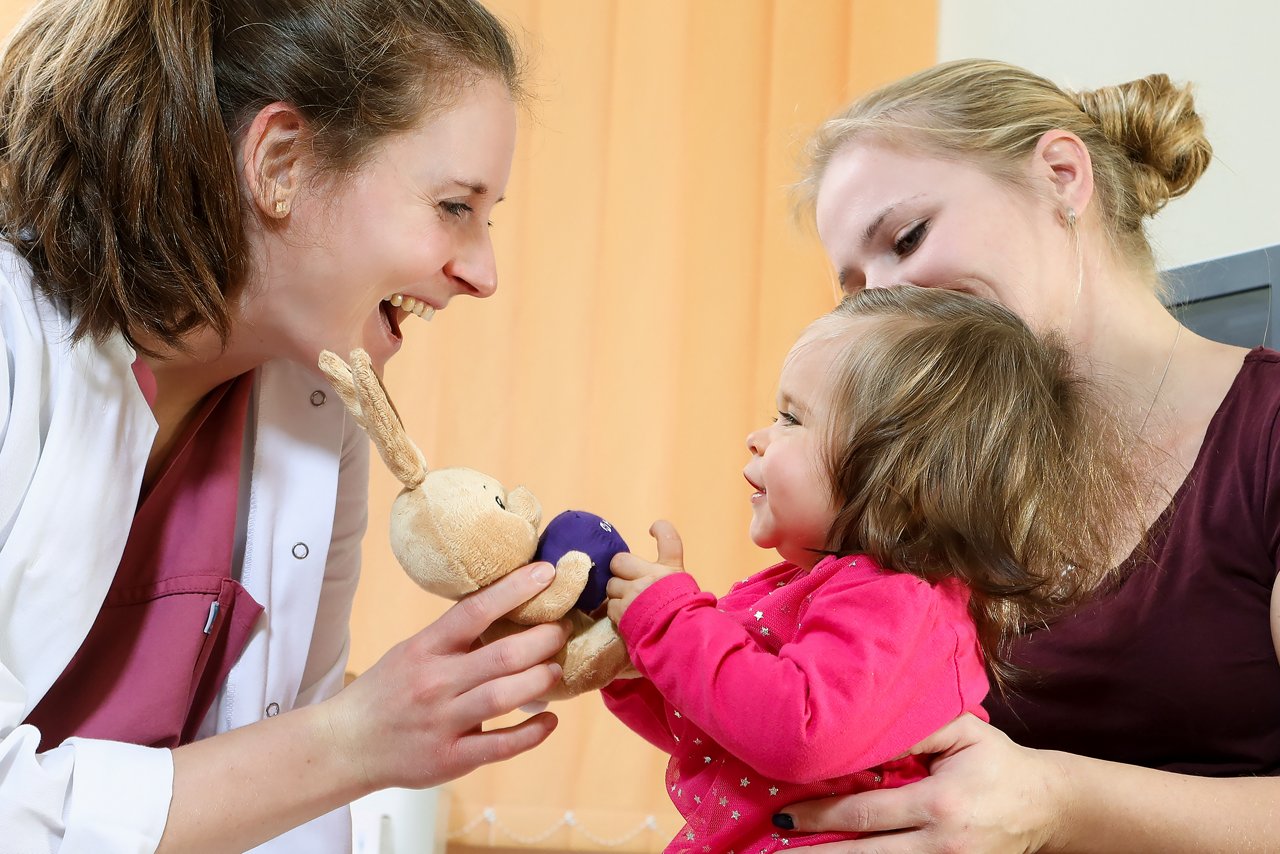 Fachärztin im freundlichen Spiel mit einem Kleinkind 