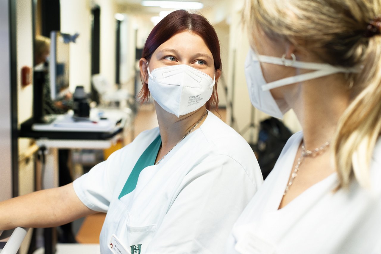 Gesundheits- und Krankenpflegerin der Onkologie auf dem Stationsflur mit Blick in Richtung Kamera