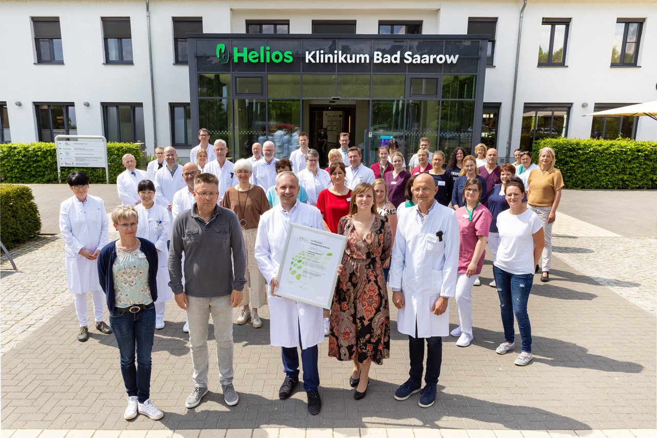 Teamfoto aller Mitarbeiter*innen des onkologischen Zentrum vor dem Haupteingang ders Helios Klinikum Bad Saarow 