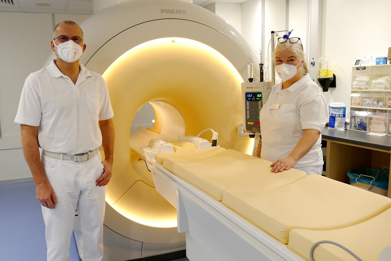 Einblick in einen Magnetresonanztomographen mit Arzt und technischer Mitarbeiterin