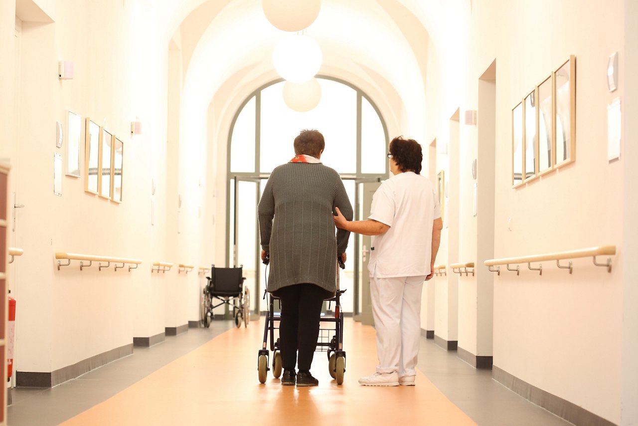 Pflegepersonal und Patientn auf dem Gang der Geriatrie im Helios Klinikum Berlin-Buch