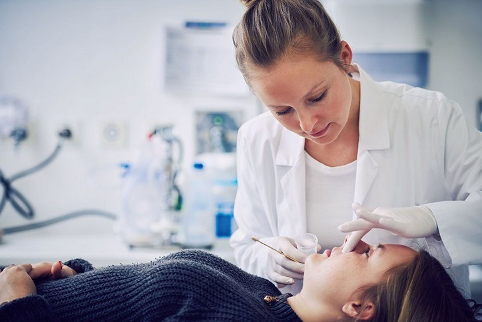 Ärztin trägt Sirolimus-Salbe bei Patientin auf