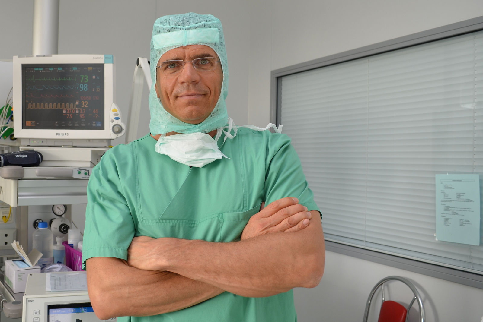 Chefarzt Prof. Birth steht im OP-Saal mit verschränkten Armen