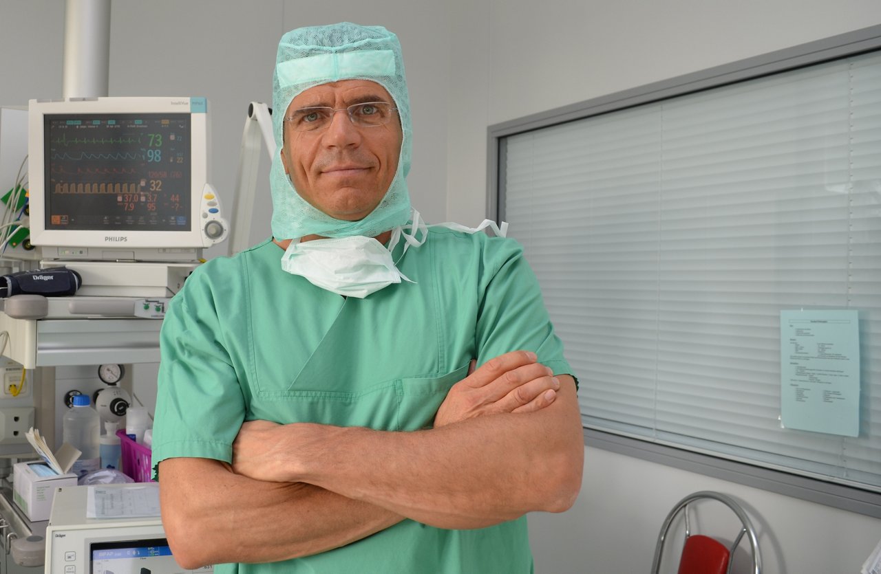 Chefarzt Prof. Birth steht im OP-Saal mit verschränkten Armen