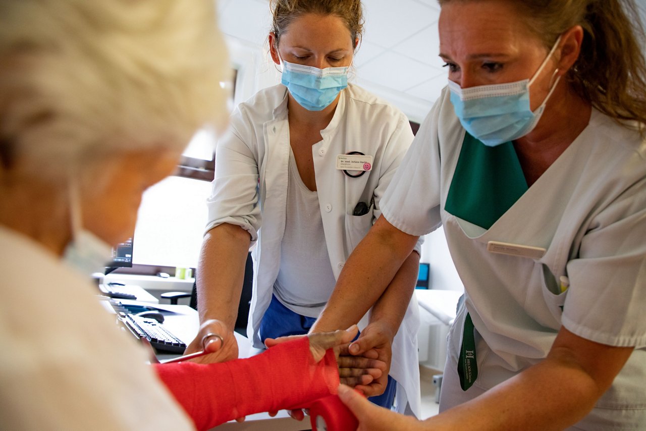 Ärztin und Schwester entfernen einen Verband.