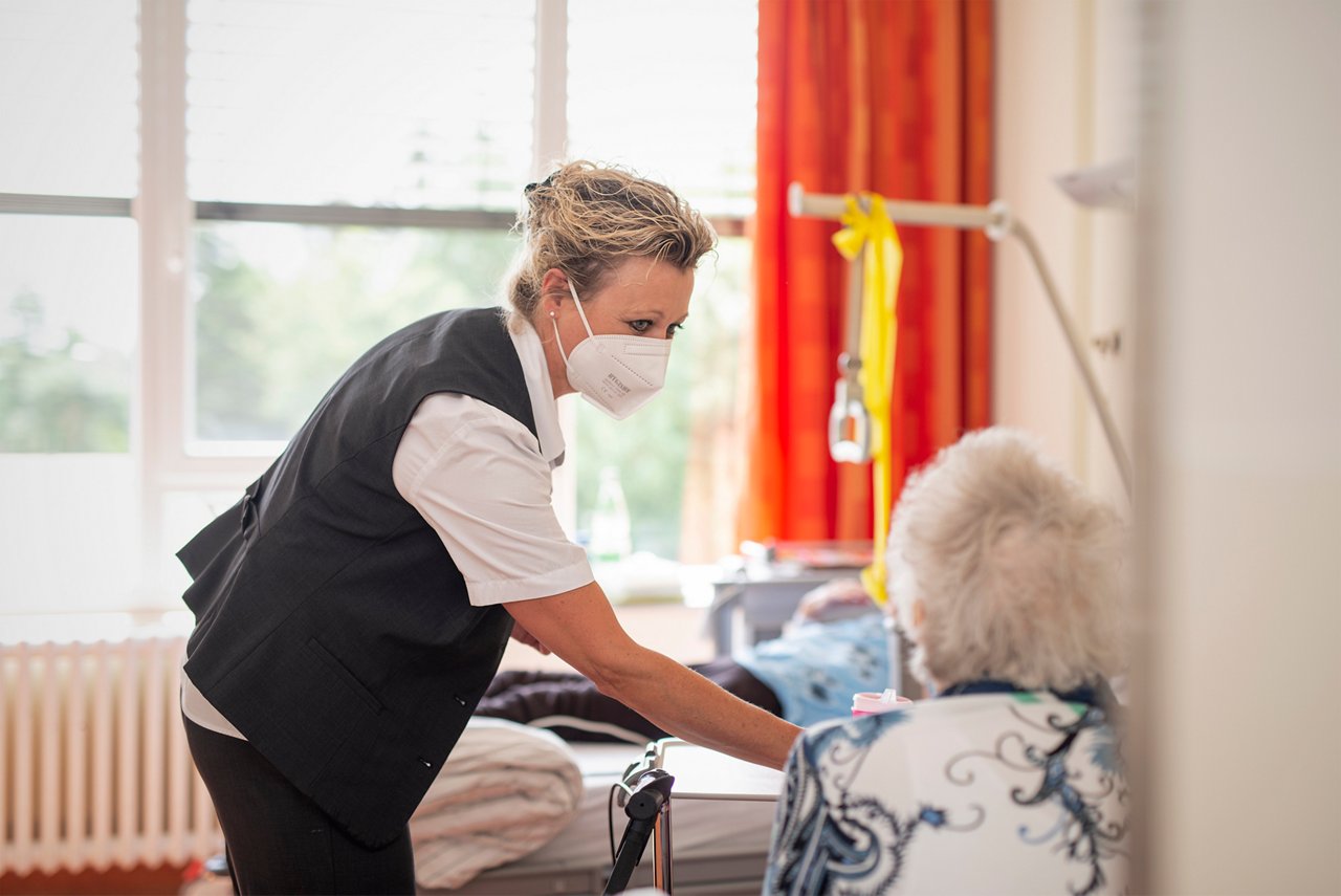 Eine Servicekraft bei der Essensausgabe für Patienten