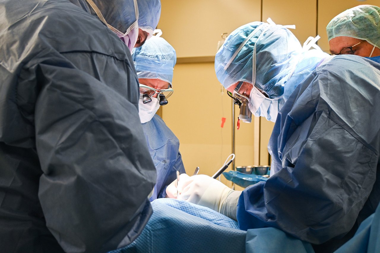 Vier Chirurgen operieren im Operationssaal