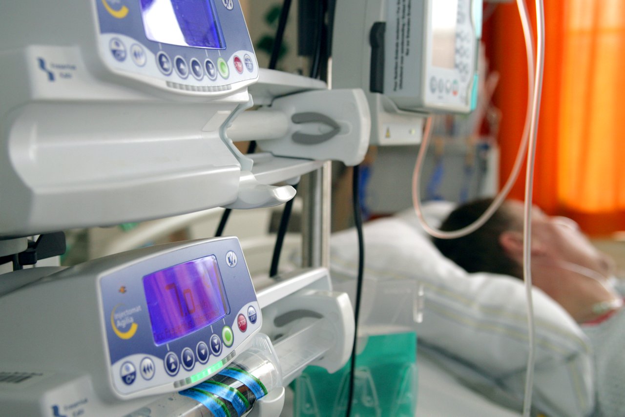 Perfusoren im Vordergrund dahinter ist ein Patient im Intensivbett zu erkennen