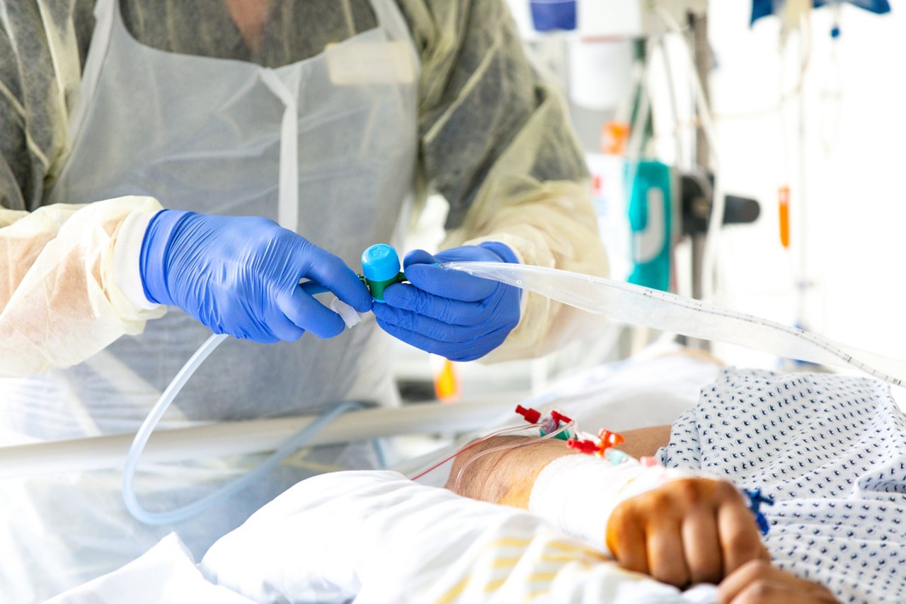 Fachkraft während intensivmedizinischer Maßnahme am Patienten