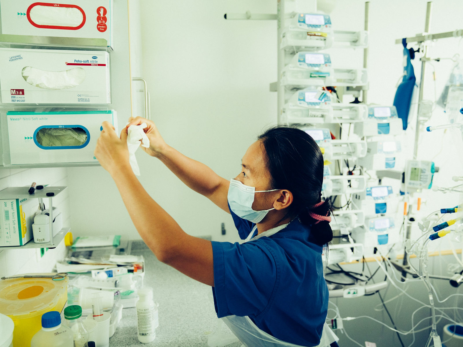 Intensivpflegekraft nimmt sich Handschuhe aus dem Spender