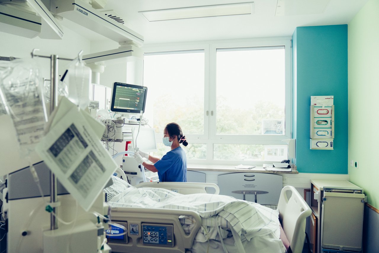 Die Intensivpflegekraft prüft im Krankenzimmer den Beatmungsschlauch