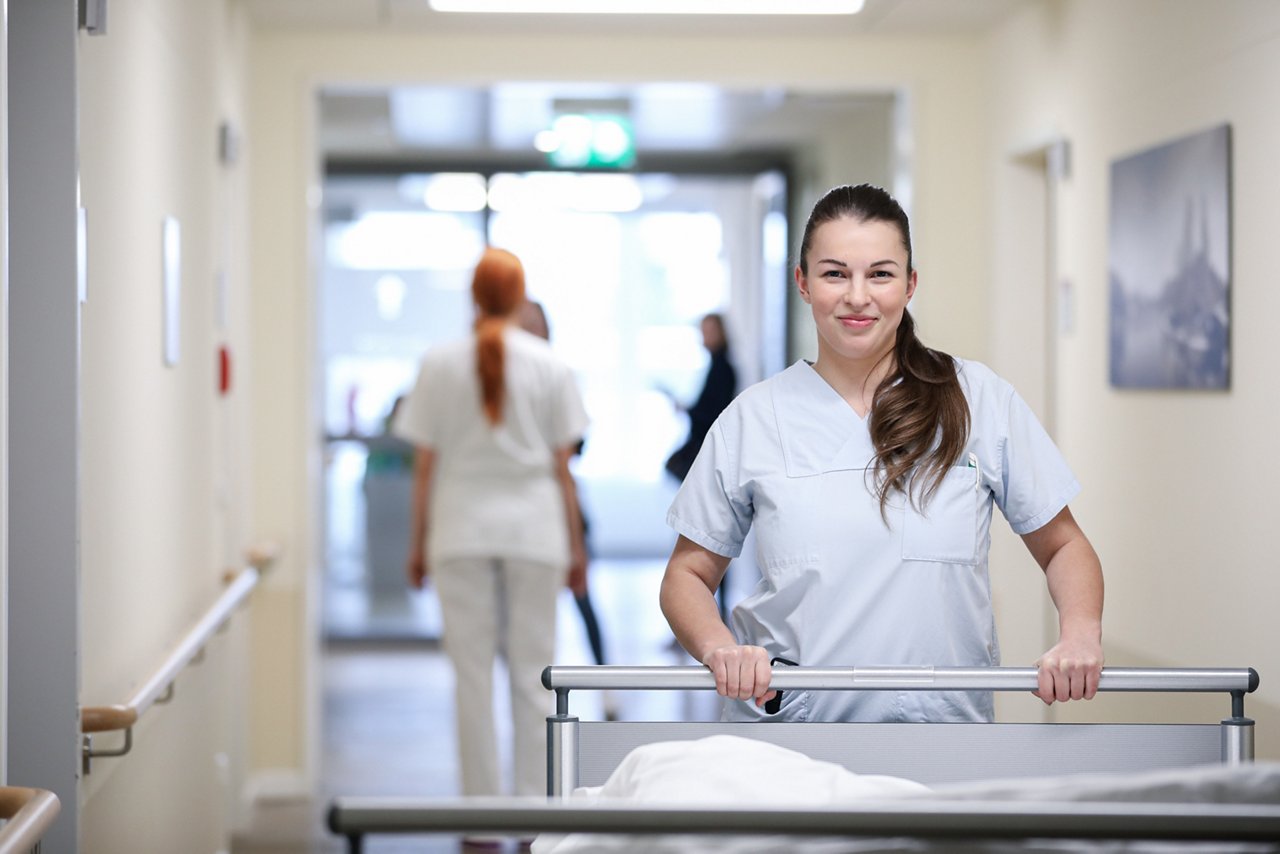 Begleiterin schiebt ein Krankenbett