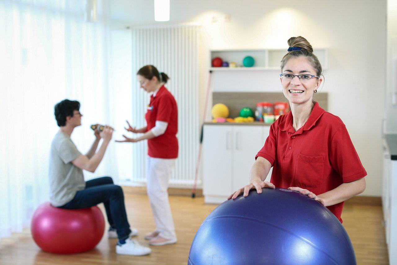 Physiotherapeutin hält einen Gymnastikball fest