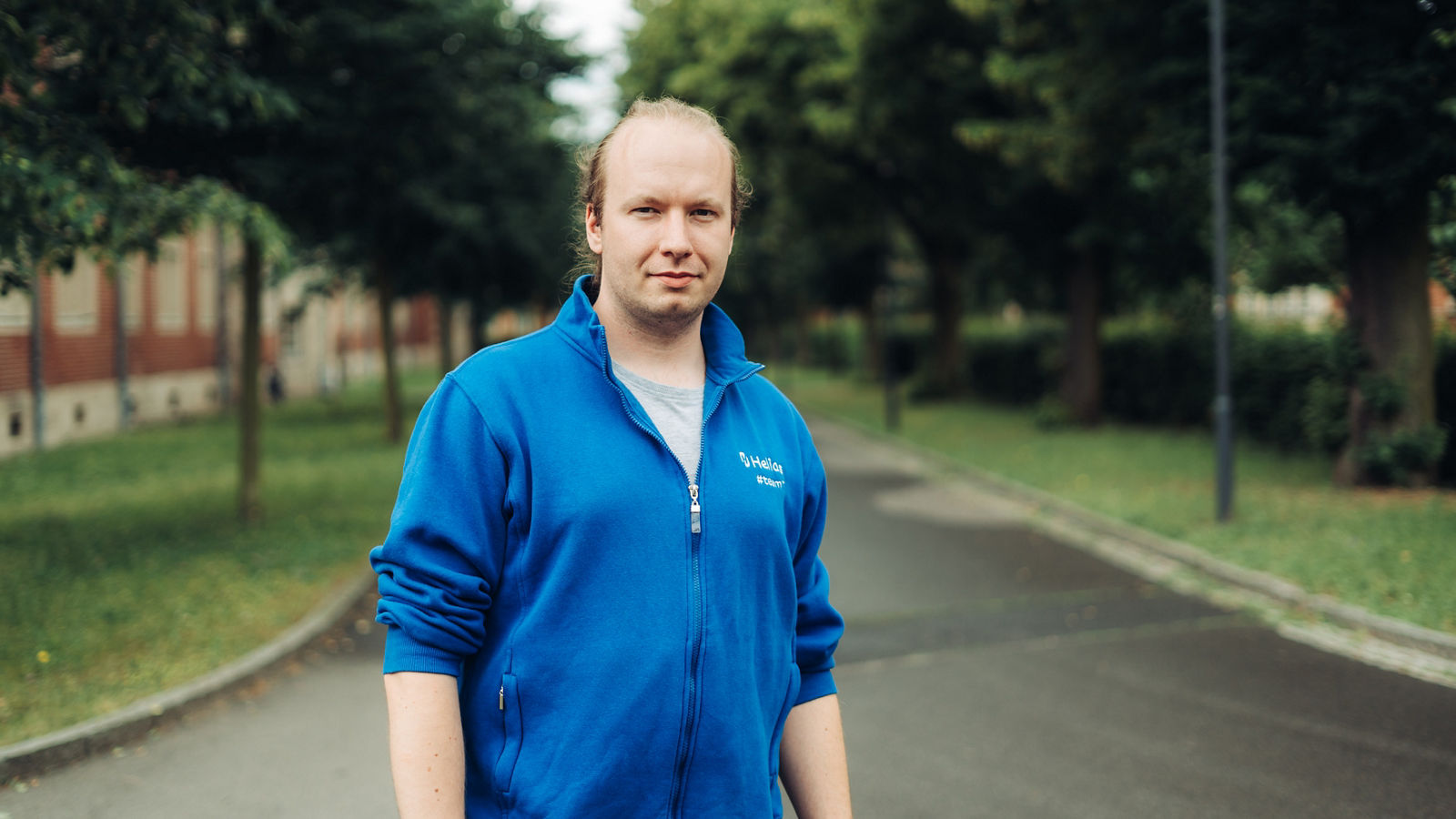Trainee in der IT steht an einer Weggabelung auf dem Klinikgelände