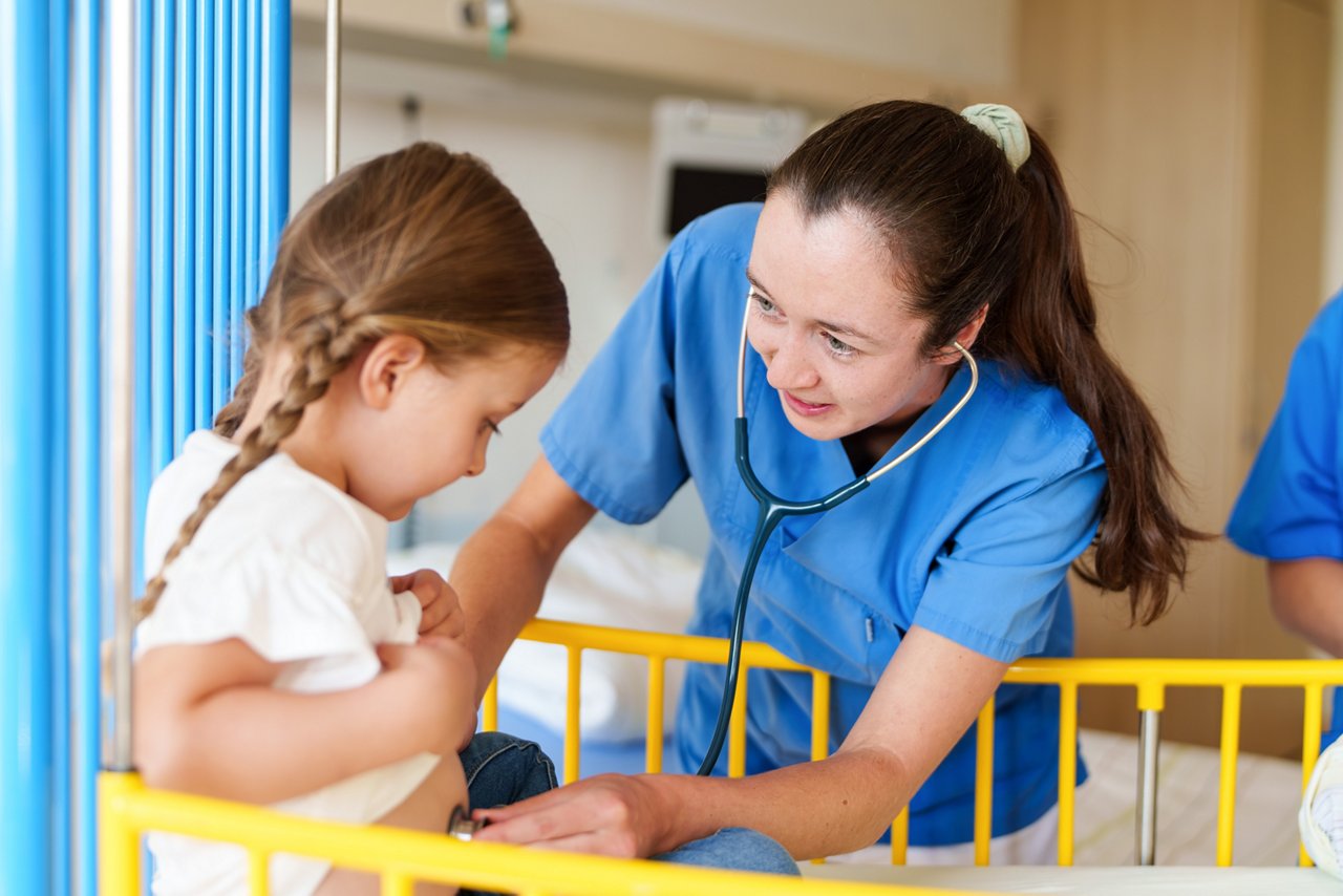 Eine Kinderärztin hört eine junge Patientin ab.
