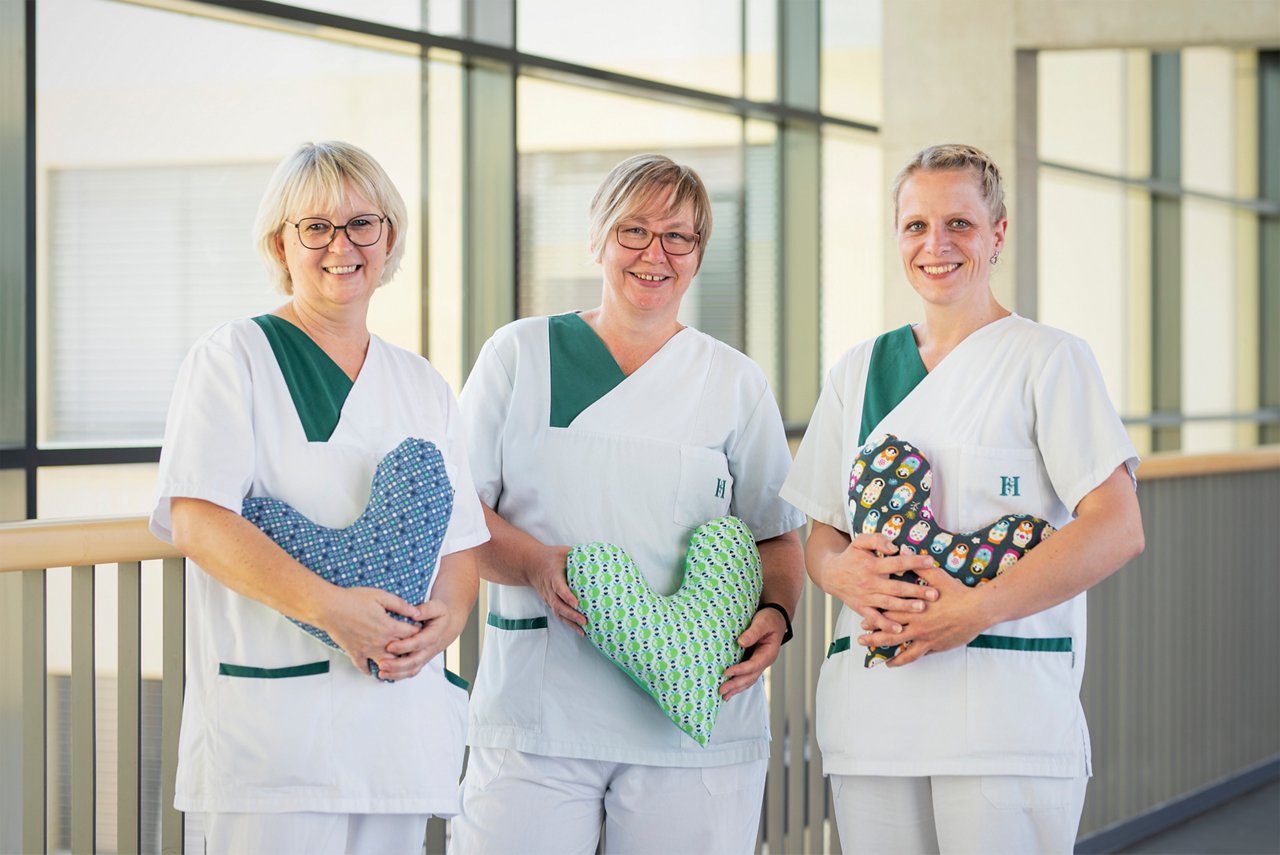  Unsere drei Breast Care Nurses mit Herzkissen in der Hand
